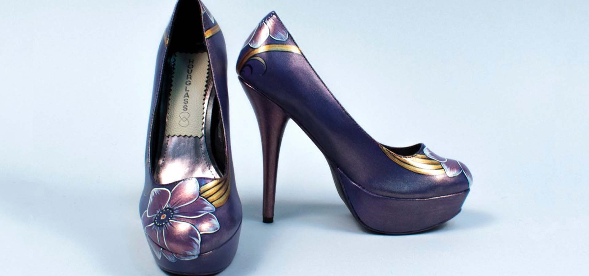 Pair of purple platform high-heel shoes painted with purple flowers.