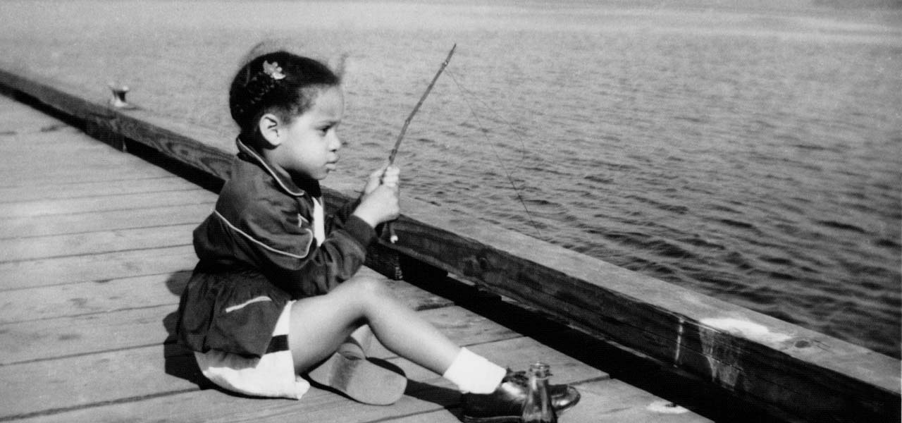 Photo of a girl sitting on a dock.