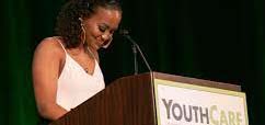 Woman talking at a podium and smiling.