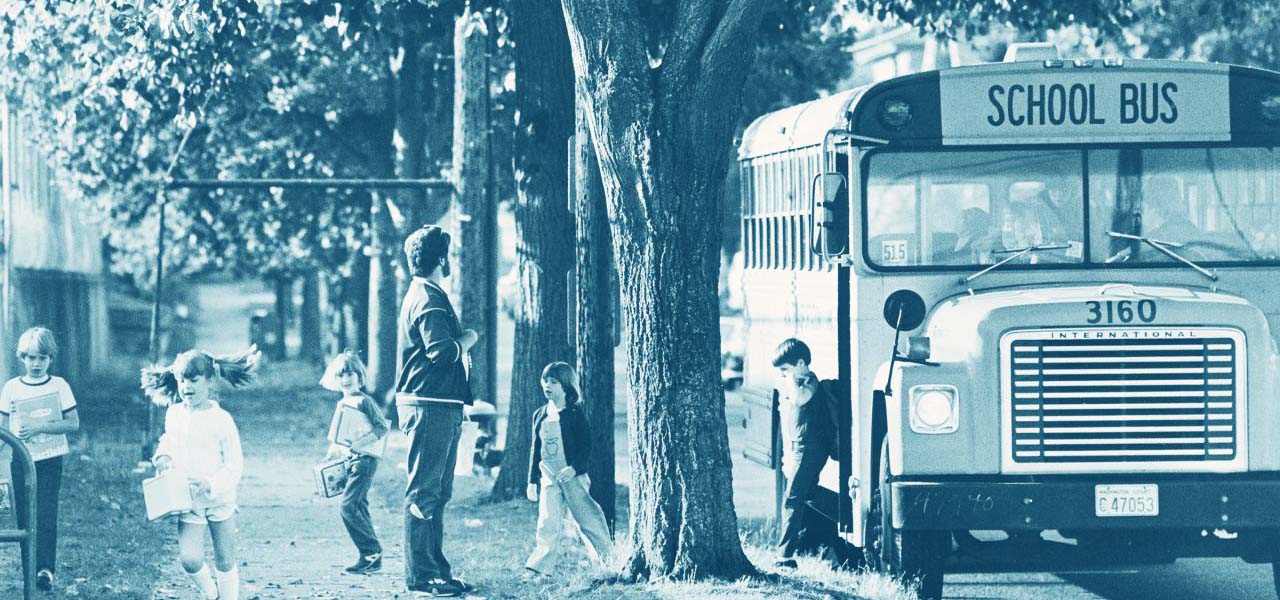 Man waiting for children to disembark a school bus.