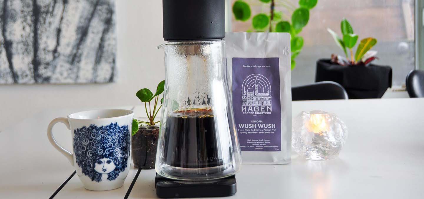Image of a coffee cup, coffee press, and package of coffee from Cafe Hagen.