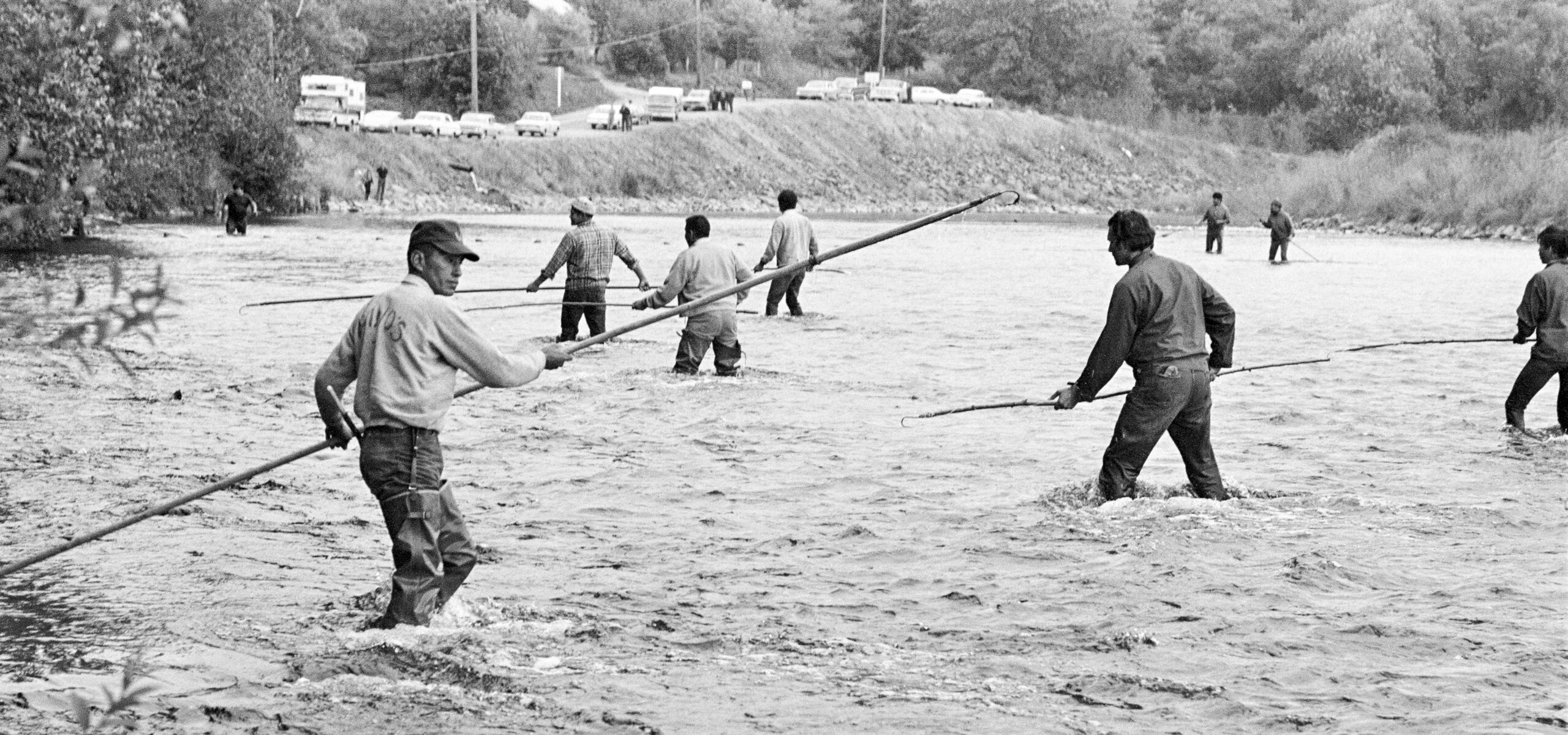 Native American men river fishing wit spears.
