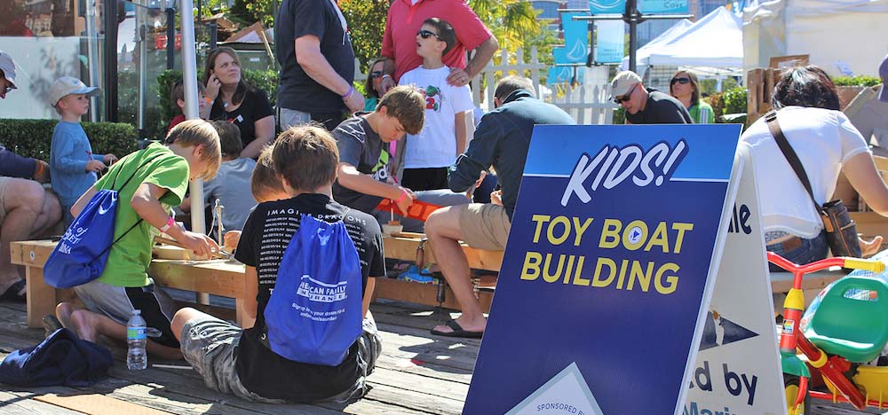 Kids making toy boats on a dock.