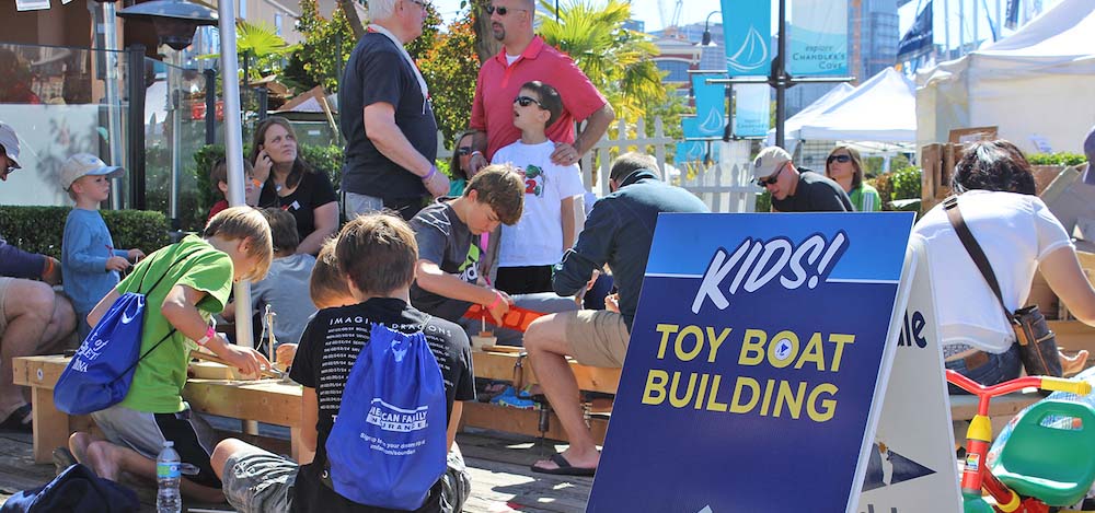 Kids building toy boats on a pier.