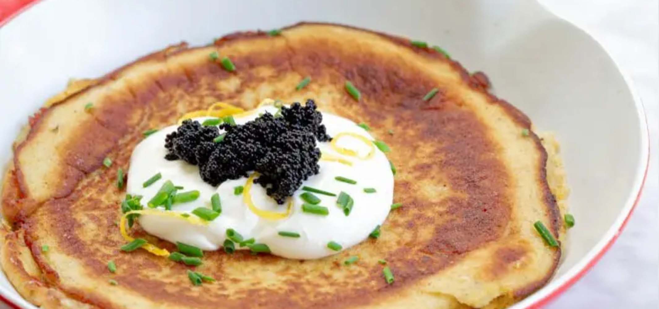 Pancake topped with whipped cream, herbs, and berries.