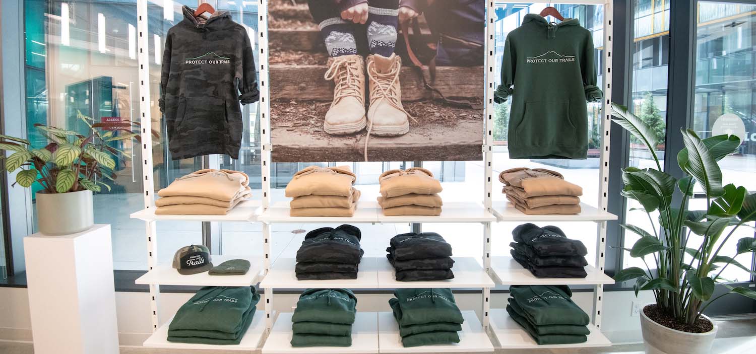 Retail window display of men's sweatshirts neatly in a row.