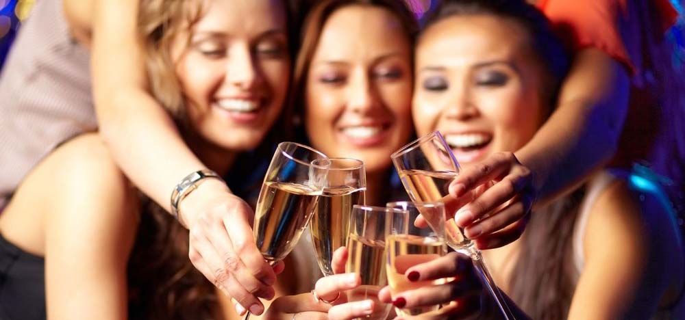 Four women toasting champagne with each other.