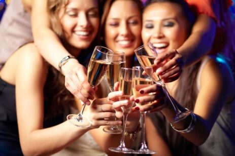 Four women toasting champagne with each other.
