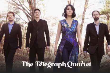 A classical quartet group posing in a forest.