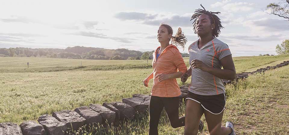 Two women running on a trail.