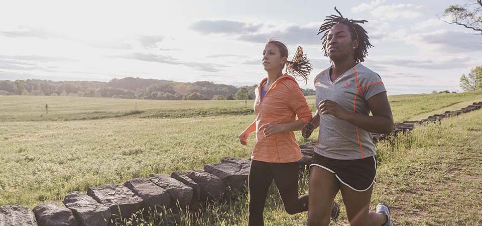 Two women running on a trail.