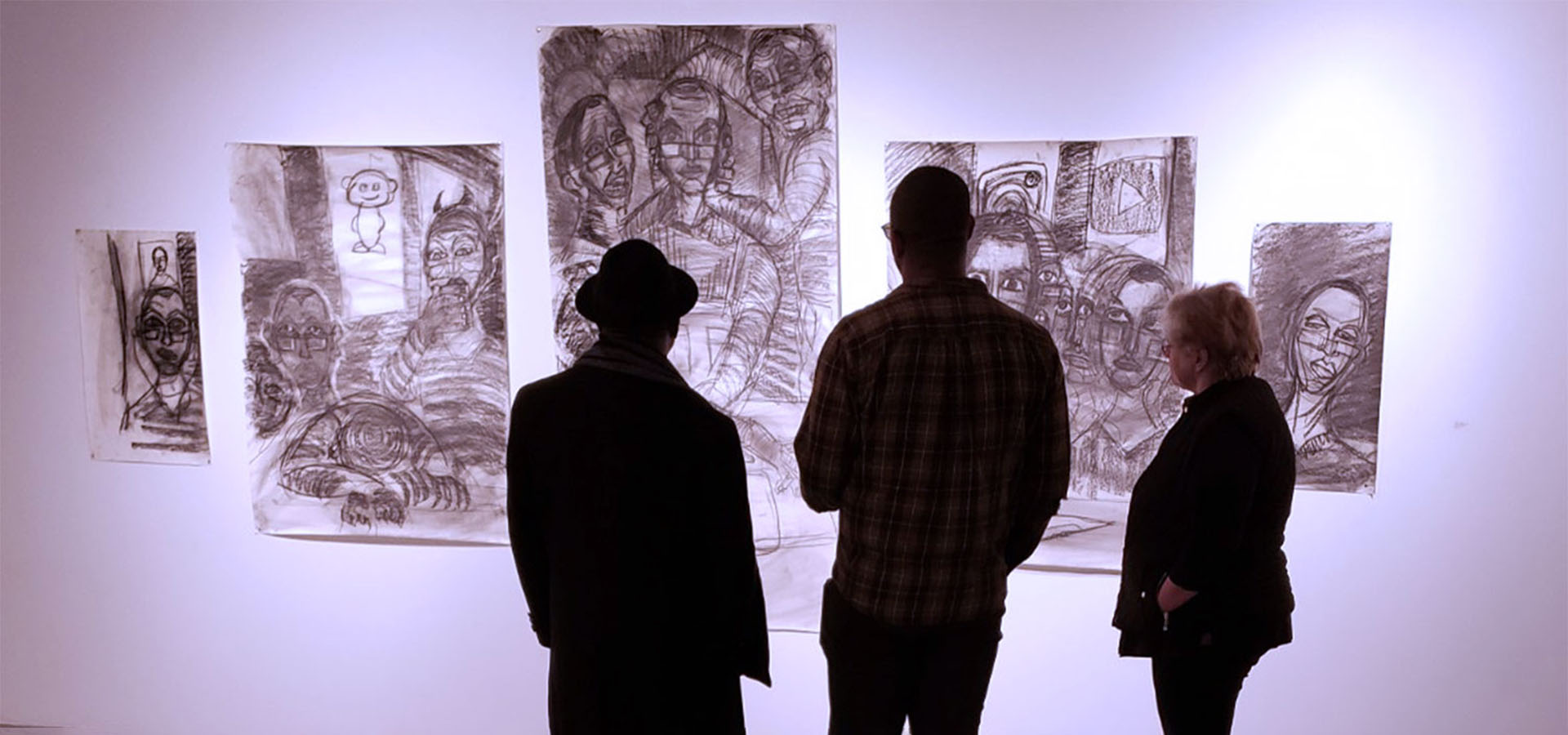 silhouetted people looking at drawings