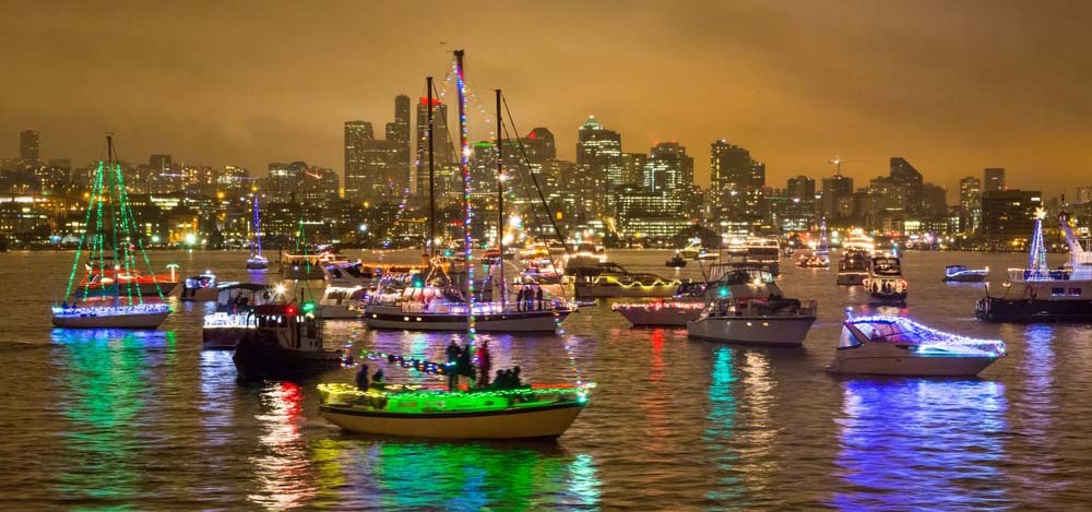 Boats on a lake decorated with holiday lights.