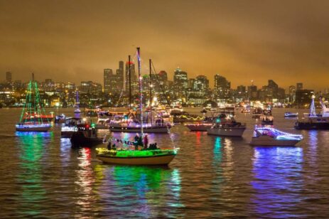 Boats on a lake decorated with holiday lights.