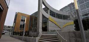 Courtyard with concrete patio and steps with yellow, modern art hung on dividing wall in the middle.