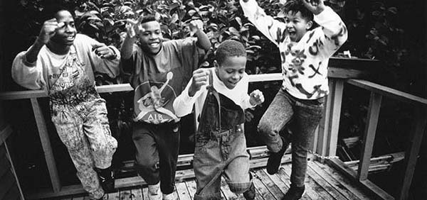 Black and white photo of four kids dancing.