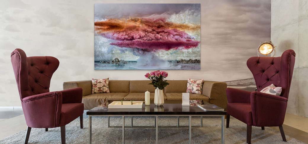 Living room designed with shades of plum and orange with an abstract painting over a sofa.