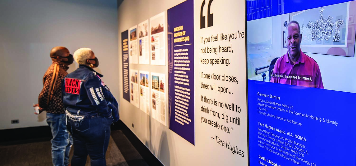 People looking at an exhibit wall in a museum.