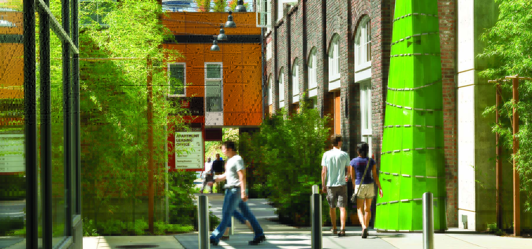 People passing a green paneled tower as modern outdoor art.