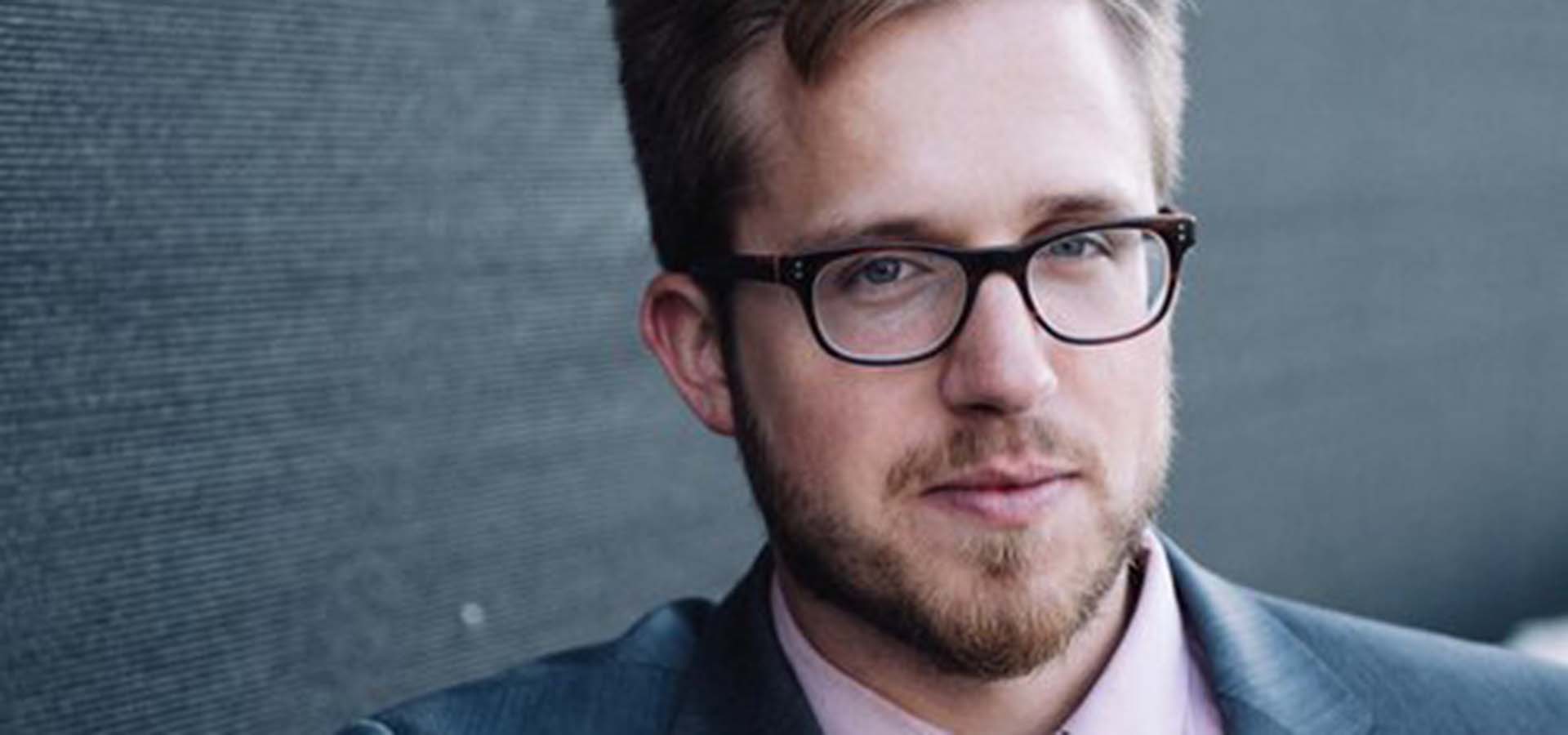 Photograph of a blonde man with glasses