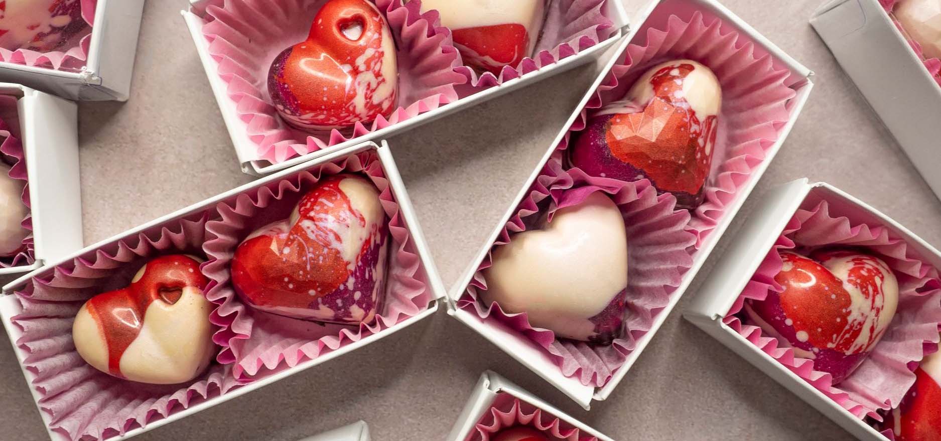 Boxes of heart-shaped red and white chocolates.