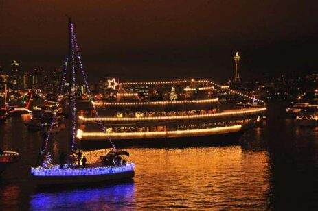 Ships sailing at night covered with holiday lights for the annual Christmas Ship festival.