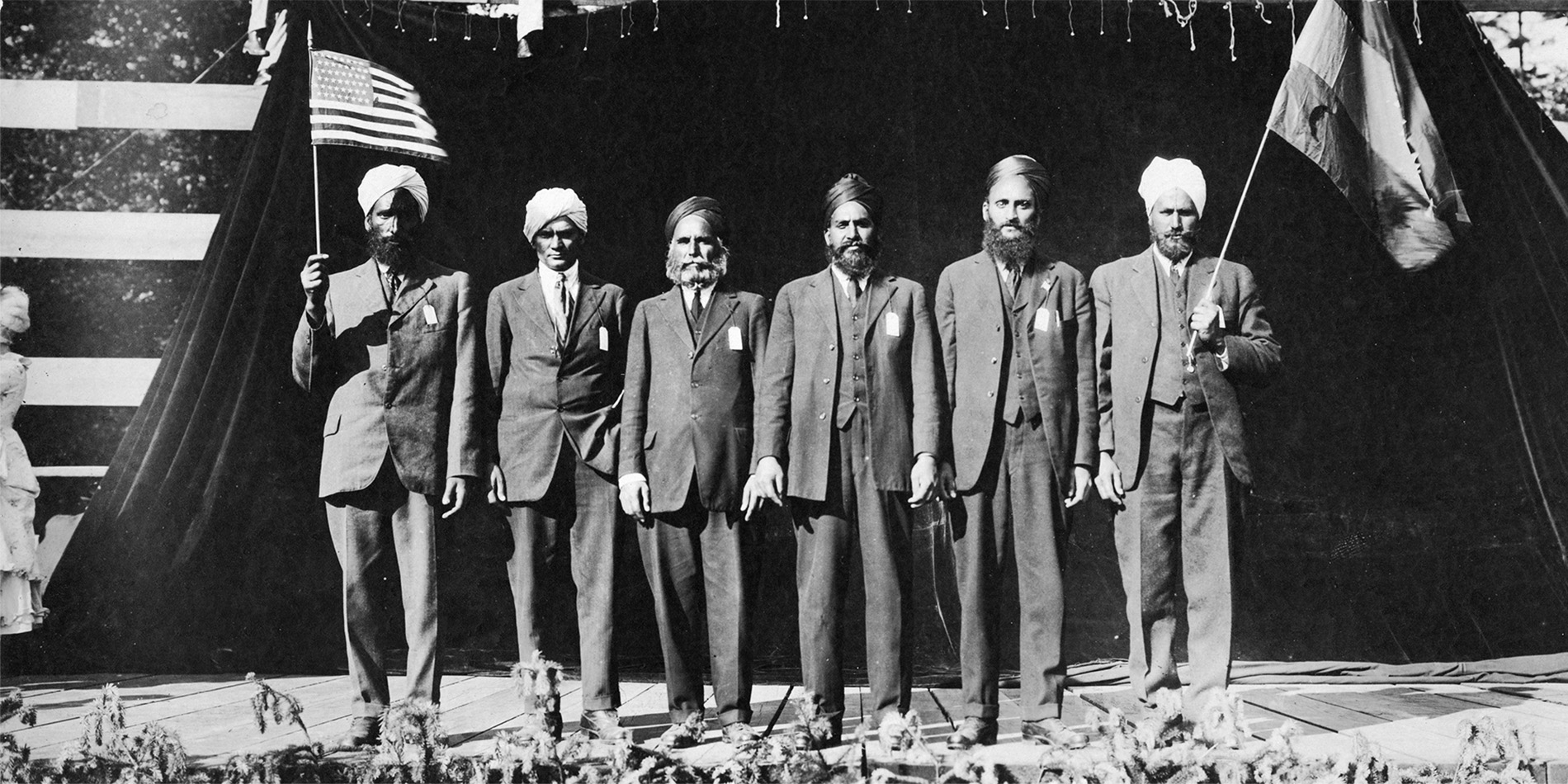 black & white photo of a group of men holding two flags