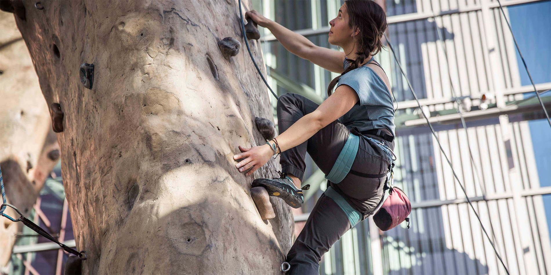 woman climbing rock wall