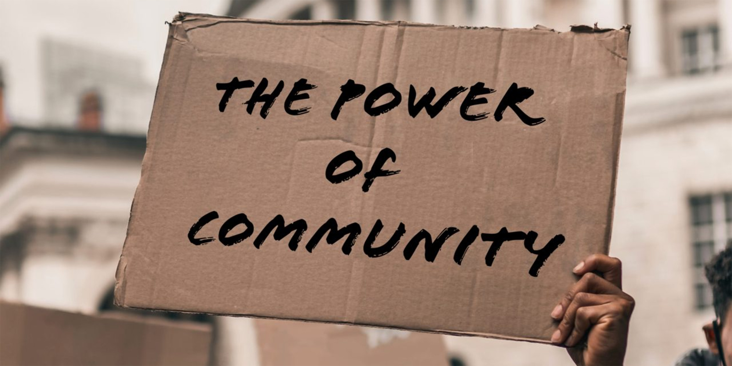 person holding power of community sign