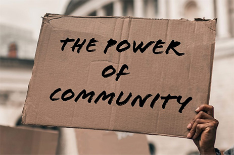 person holding power of community sign