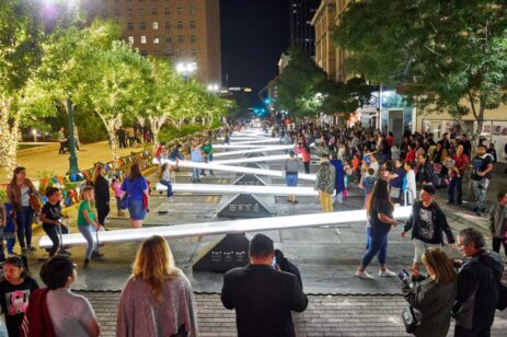 People riding on lit up seesaw rides.