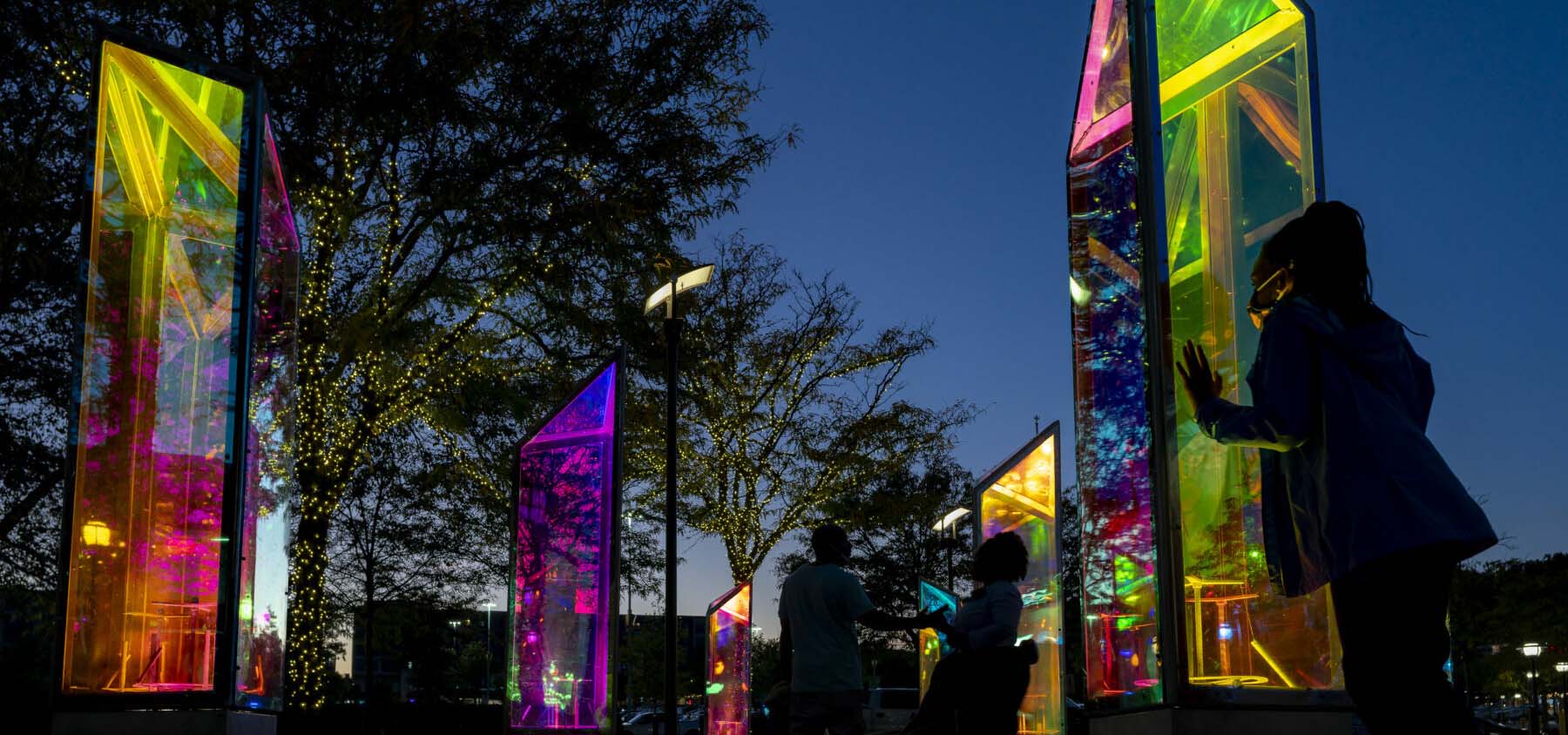 Neon prism outdoor art glowing at sunset.