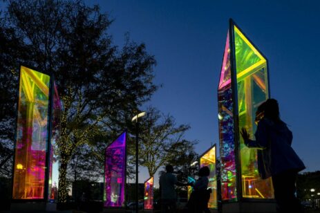 Neon prism outdoor art glowing at sunset.