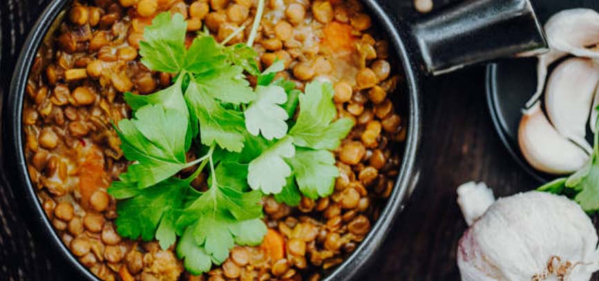 Bowl of Indian Dahl topped with herbs.