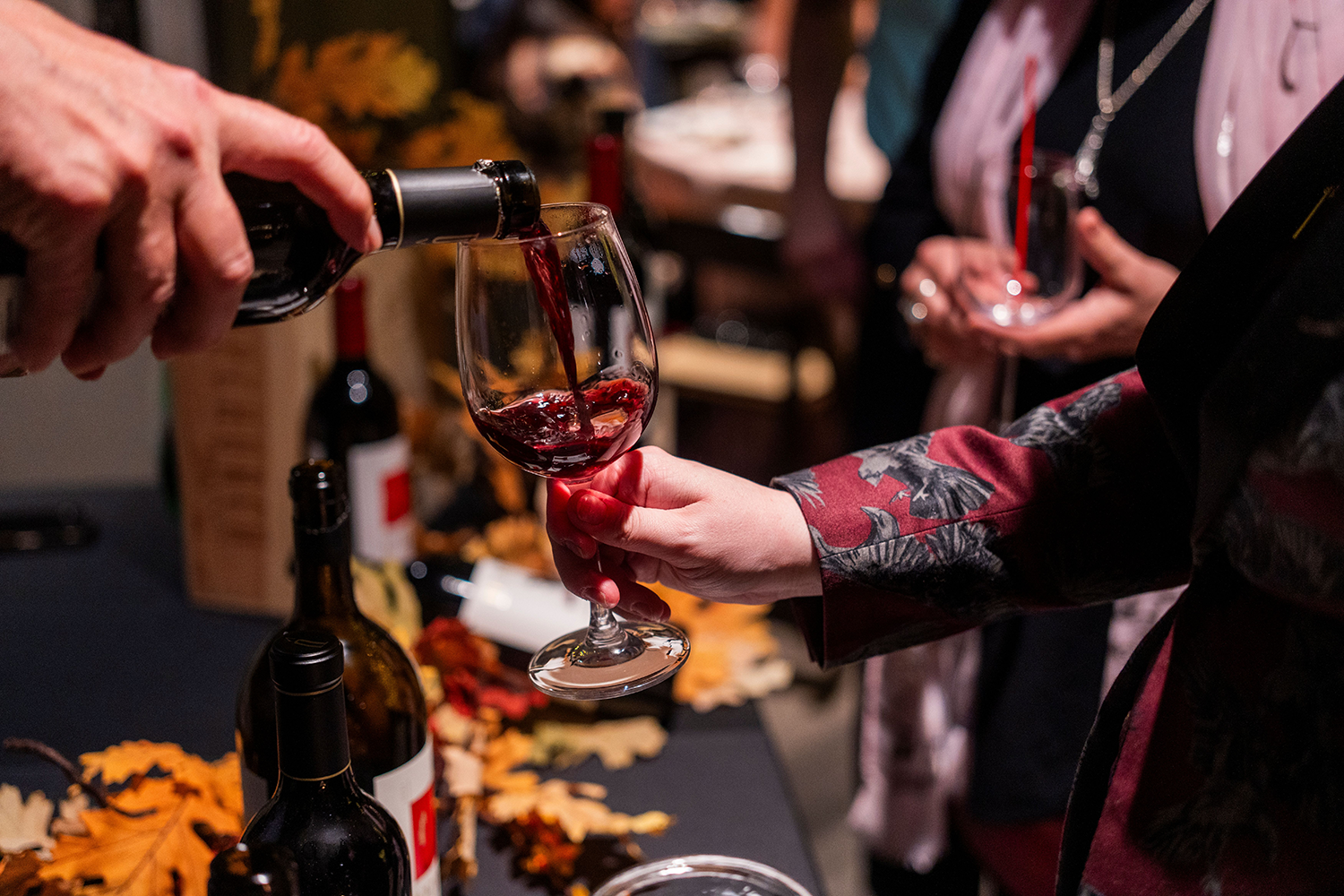 person pouring glass of wine
