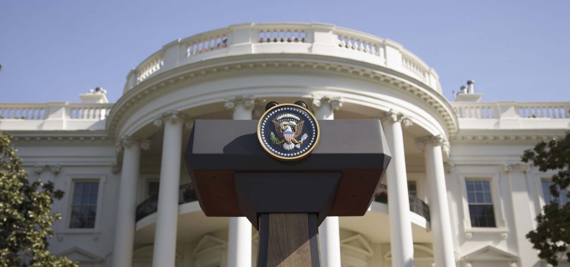 Photo of Presidential podium in front of the White House.