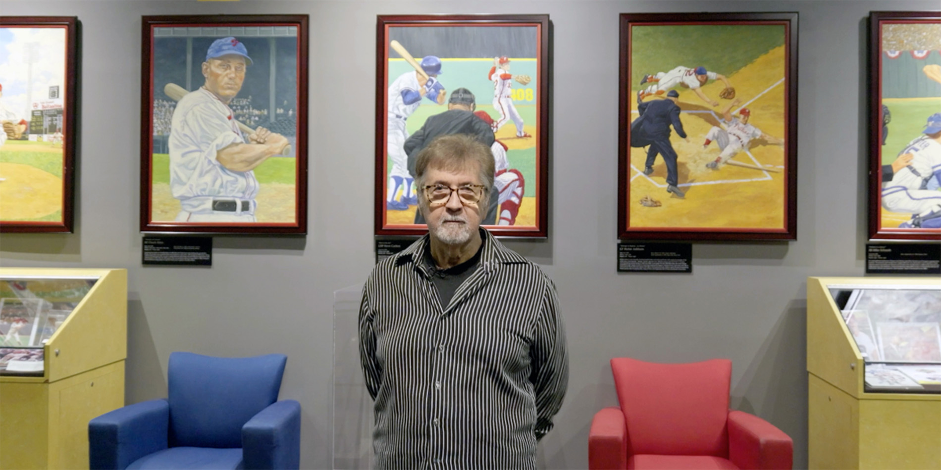 Dick Perez in front of paintings