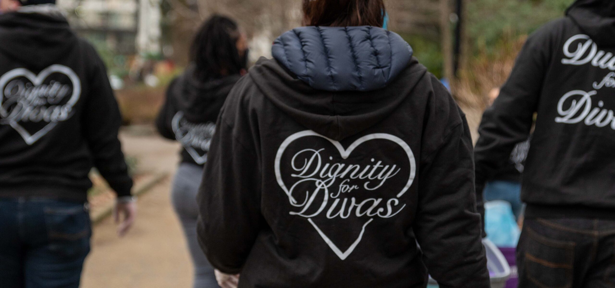 Volunteer team passing out hygiene kits to homeless women.