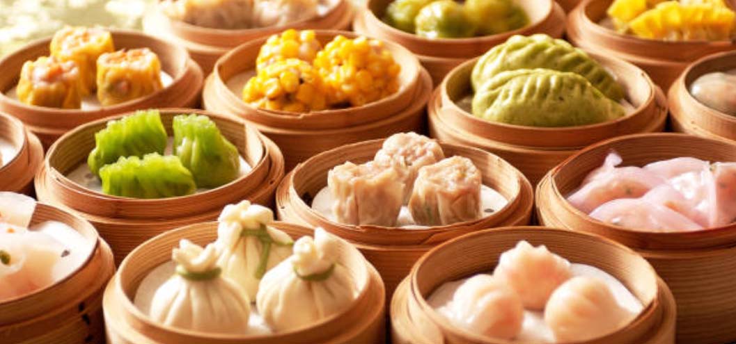 Array of dim sum steamers will varieties of dumplings.