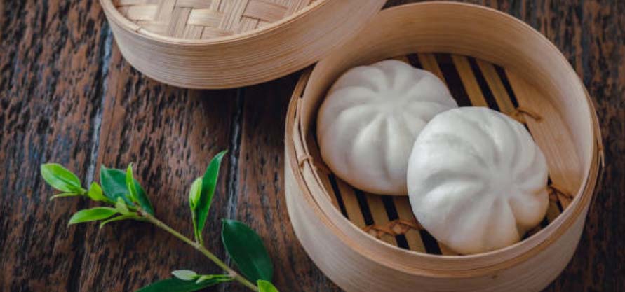 Bao buns in a bamboo steamer.