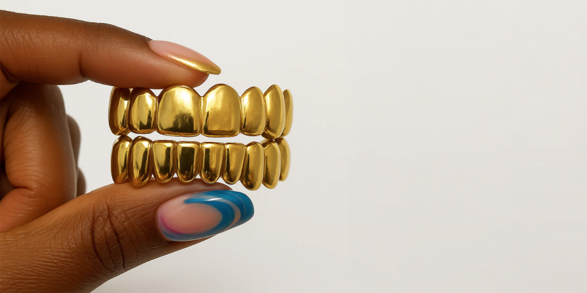 person holding gold mouth grill
