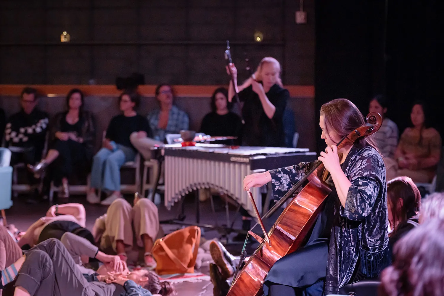 2 musicians playing with listeners around them