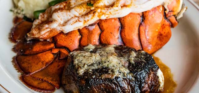 Steak filet and lobster tail dinner on a white plate.