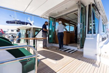 Two men talking on a yacht deck.