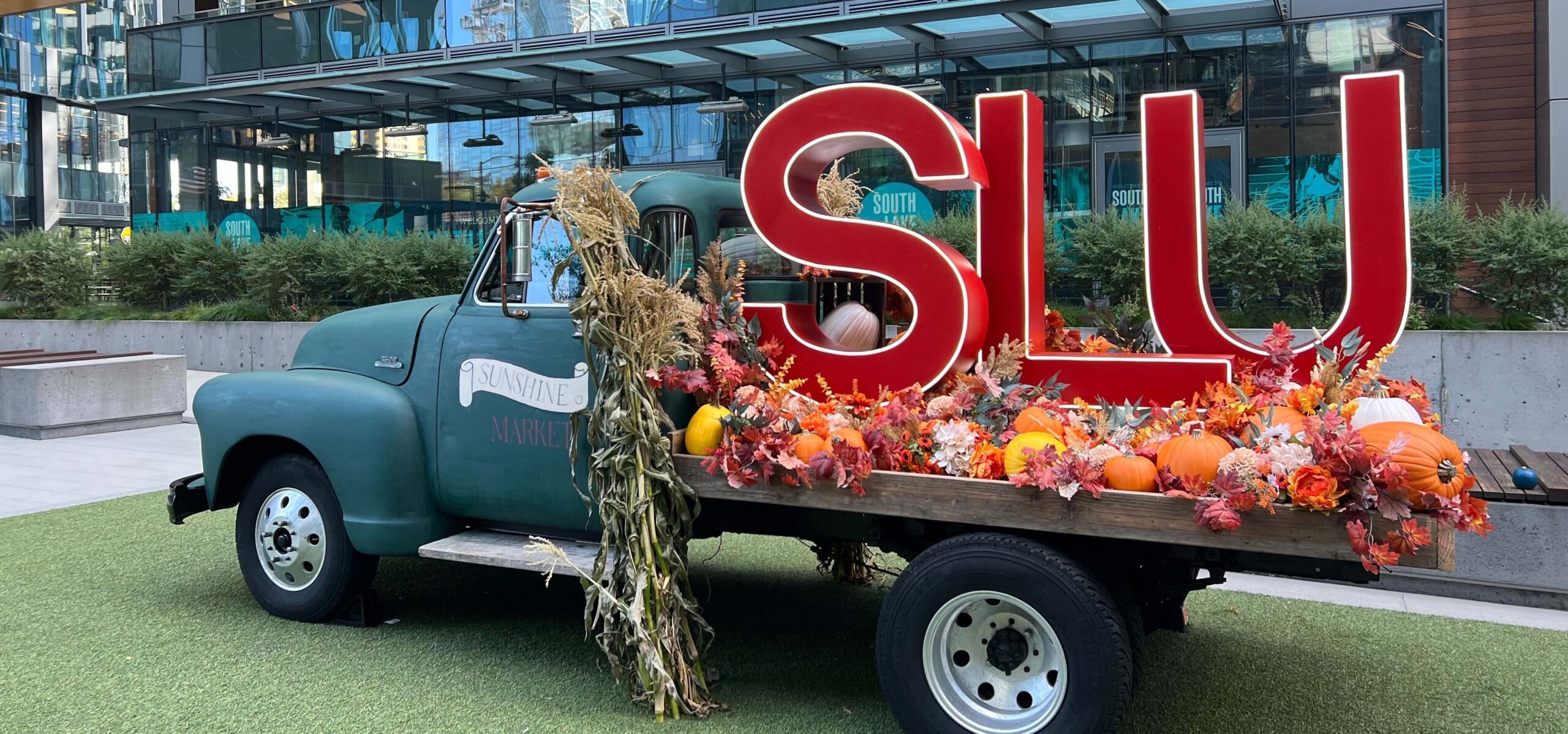 A vintage truck filled with fall foliage and pumpkins.