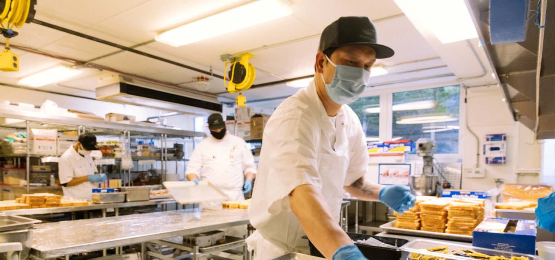 Food service worker making sandwiches wearing a face mask