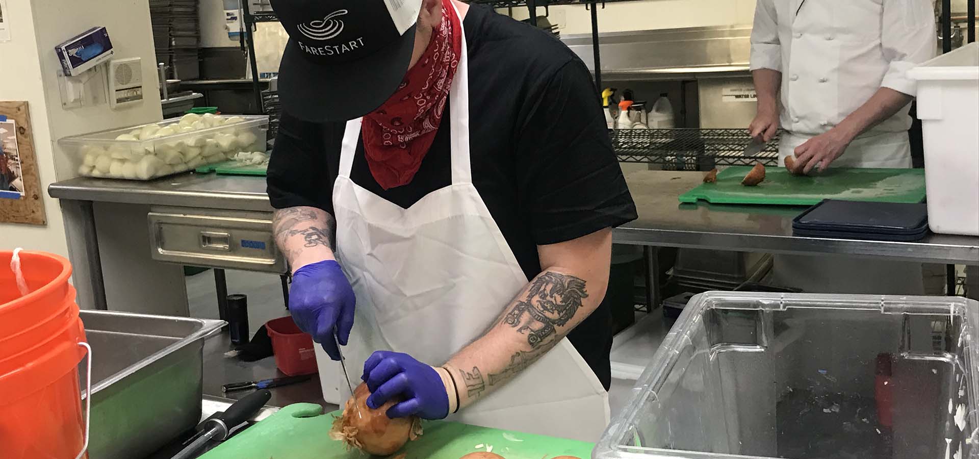 Volunteer chef cutting onions for FareStart.