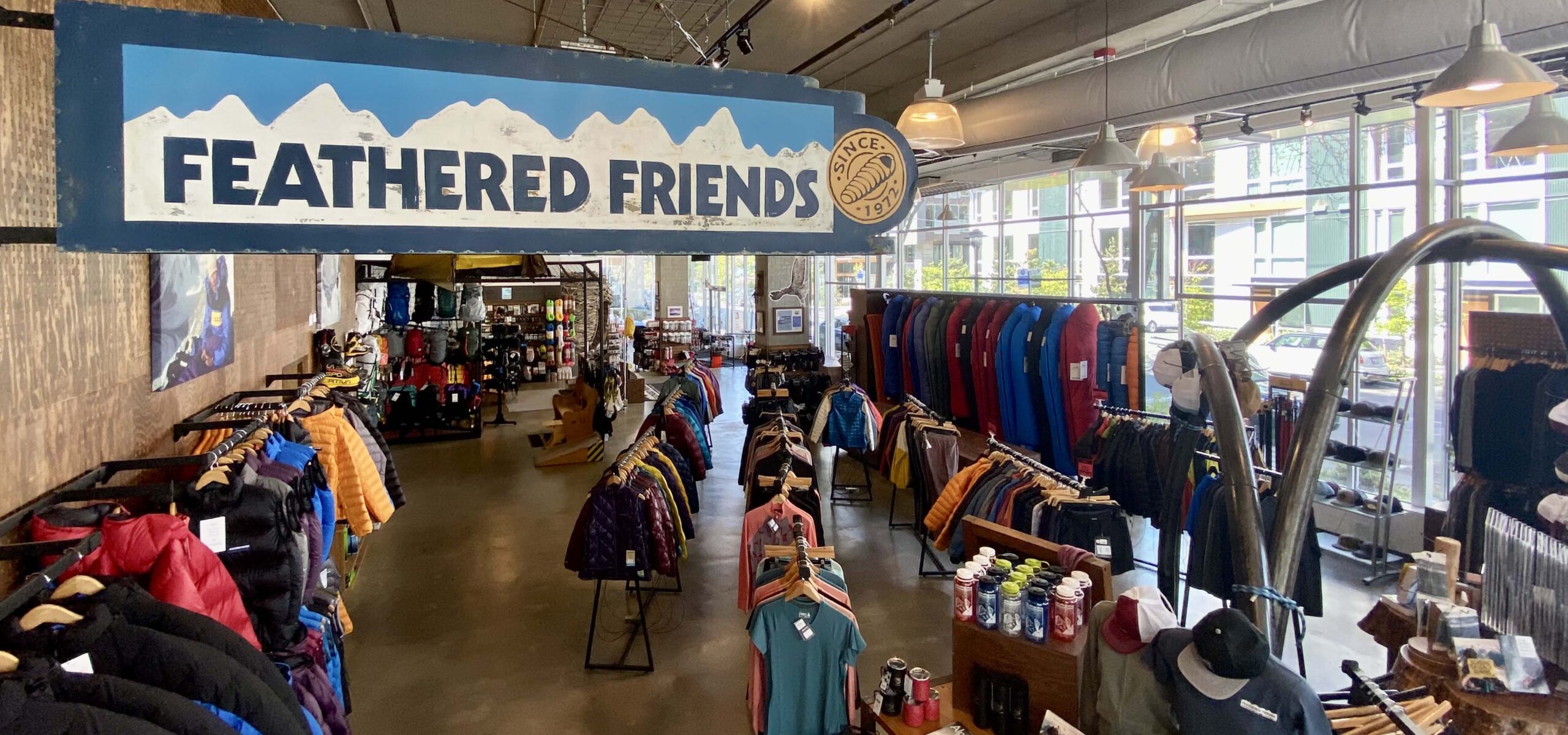 Inside of an outdoor gear shop selling sleeping bags, coats, and clothing.