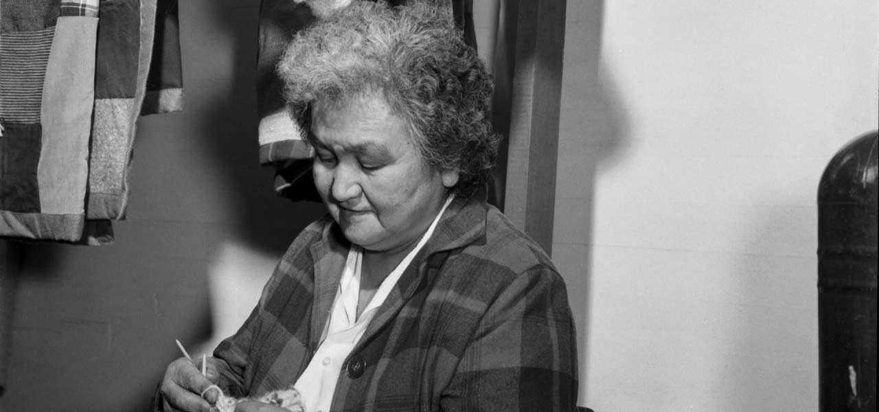 An older woman knitting.