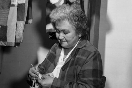 An older woman knitting.